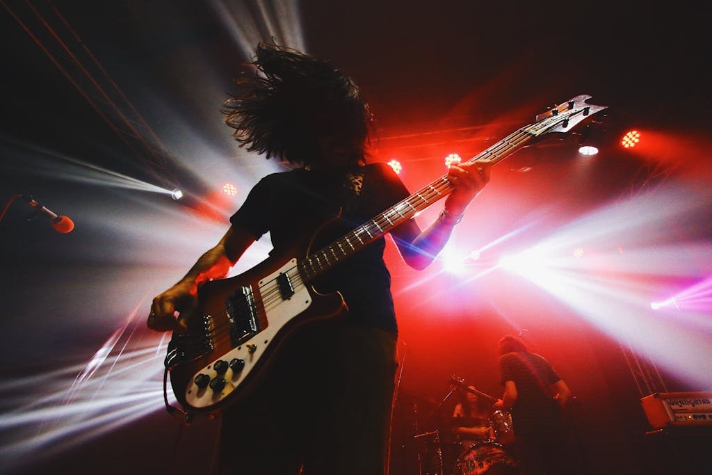 🎬 Legendary Live Performances 2 Intense live rock concert capturing a bassist in action under vibrant stage lights.