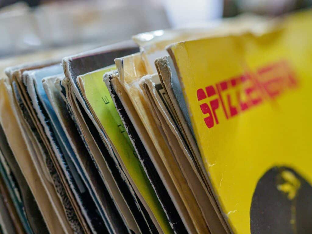 Colorful vintage vinyl record sleeves stacked together with a blurred background.