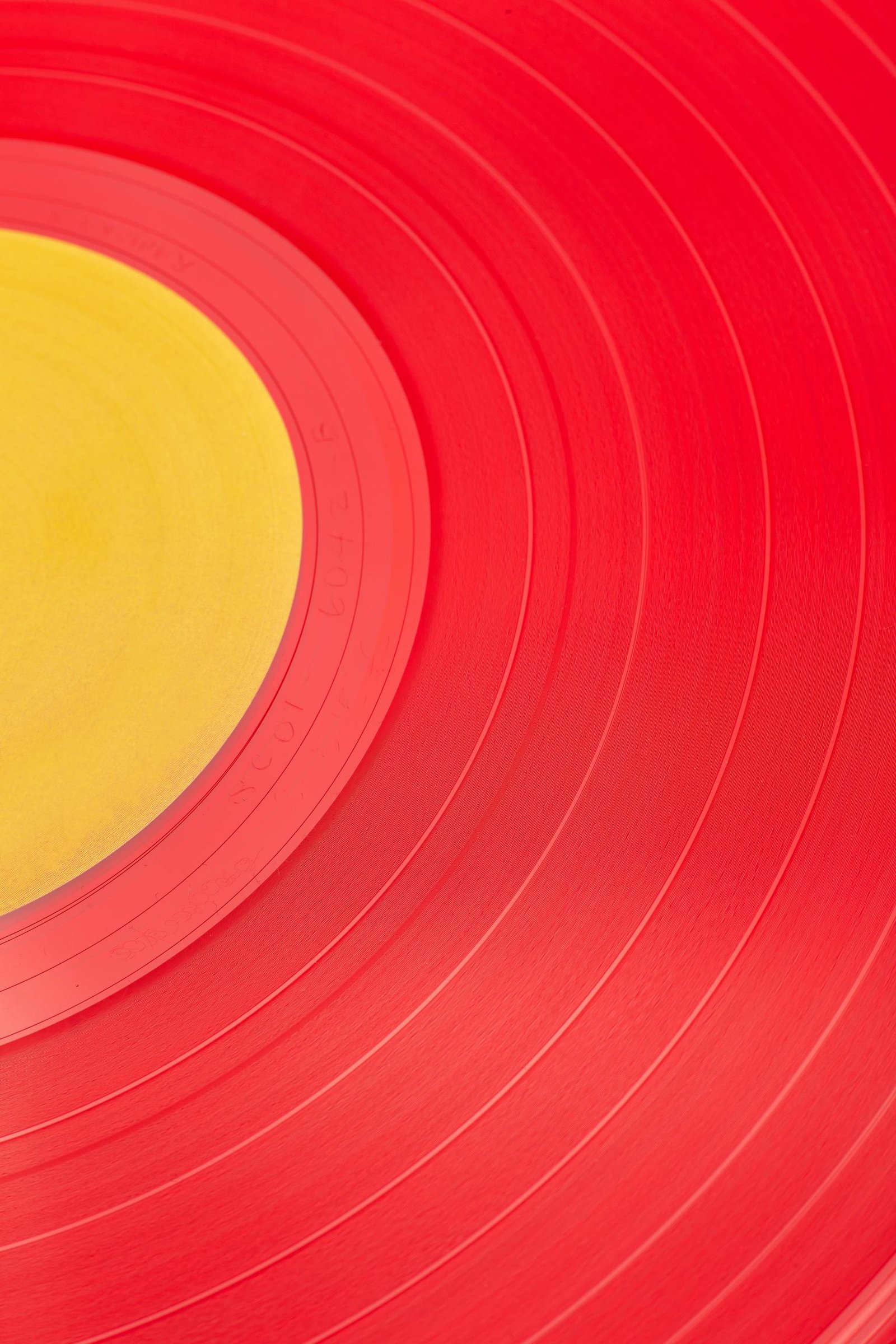 Vibrant red and yellow close-up of a vinyl record, perfect for music and design themes.
