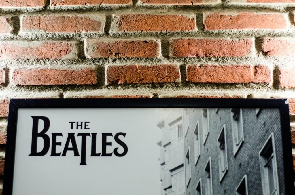 📖 Music Stories 1 A vintage Beatles poster against a classic brick wall background, emphasizing retro style.