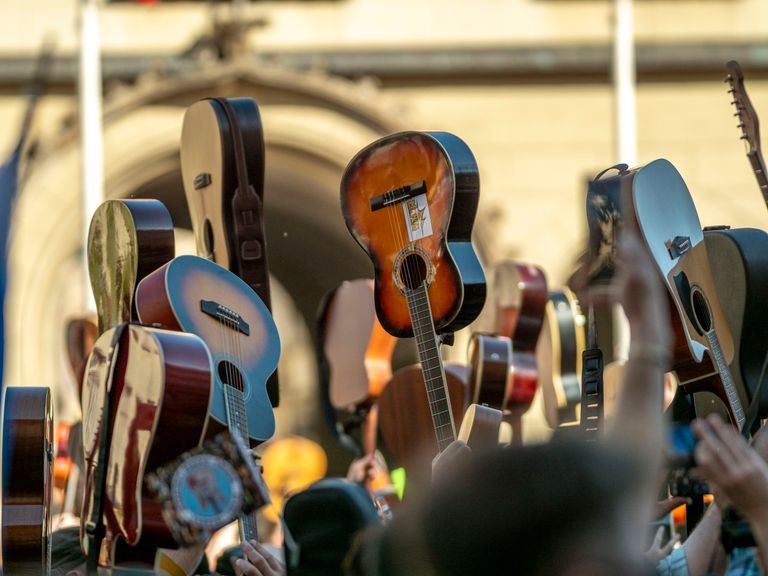 Chitarra Western: Guida alla Scelta tra Martin, Gibson, Taylor e i Grandi Marchi 5 Vibrant scene of guitars raised in celebration at Wrocław's public gathering.